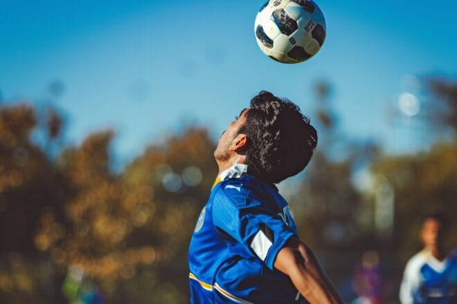 Illustration. Un footballeur contrôle le ballon de la tête.