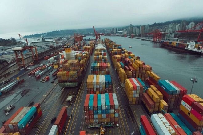 Image d'illustration. Chargement de conteneurs multicolores sur un cargo dans port animé