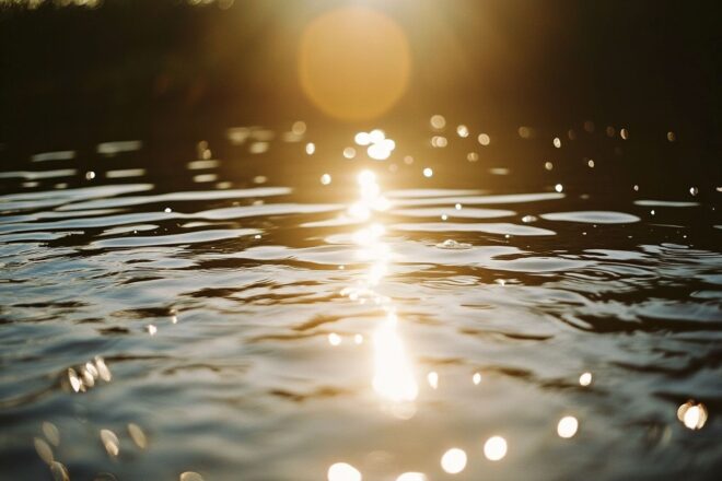 Une surface étincelante d'un lac reflétant la chaleur du soleil de midi.