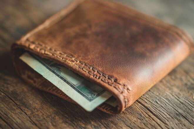 Portefeuille avec billet sur table en bois rustique