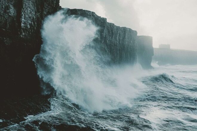 Vagues massives contre falaises rocheuses