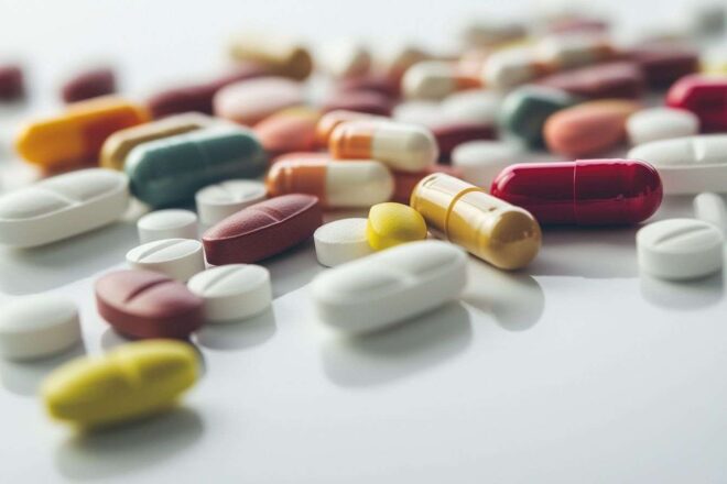 Collection de comprimés et capsules sur surface blanche