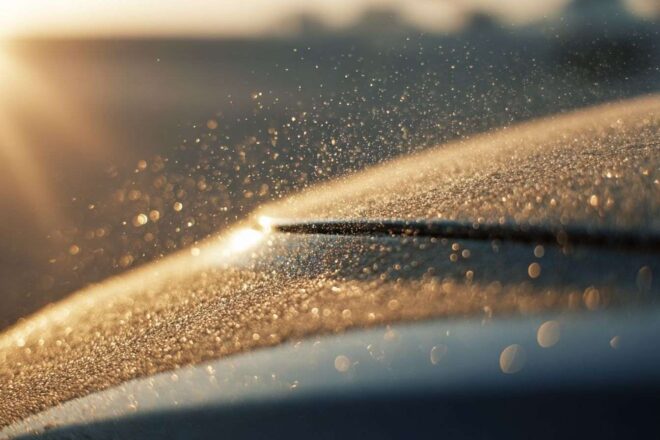 Gros plan sur le sable fin sur la carrosserie brillante d une voiture