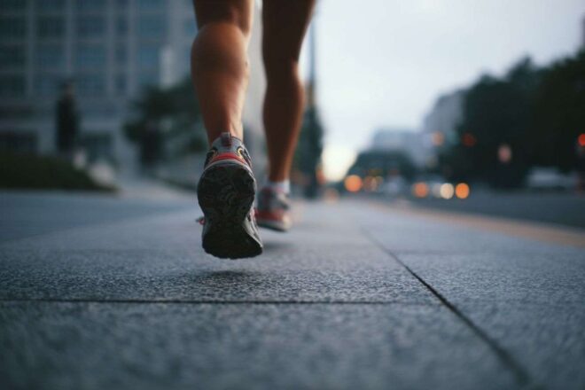 Les pieds du coureur frappant le trottoir