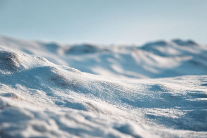 Neige douce recouvrant des collines basses sous un ciel lumineux