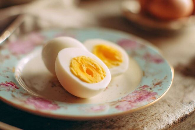 Œuf dur coupé en deux sur assiette pastel