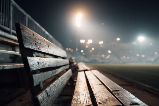 Banc de football vide sous lumières de stade