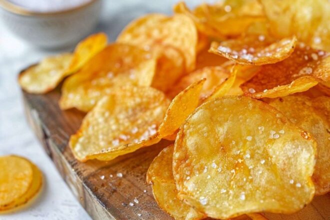 Gros plan chips maison dorées vinaigre sel mer planche bois