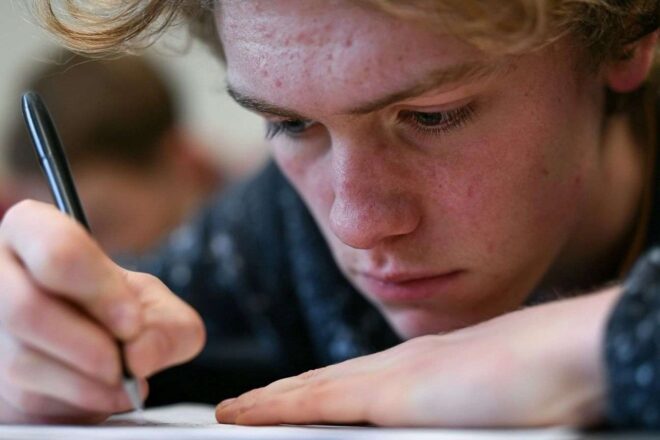 Gros plan sur les mains d un étudiant écrivant pendant un examen