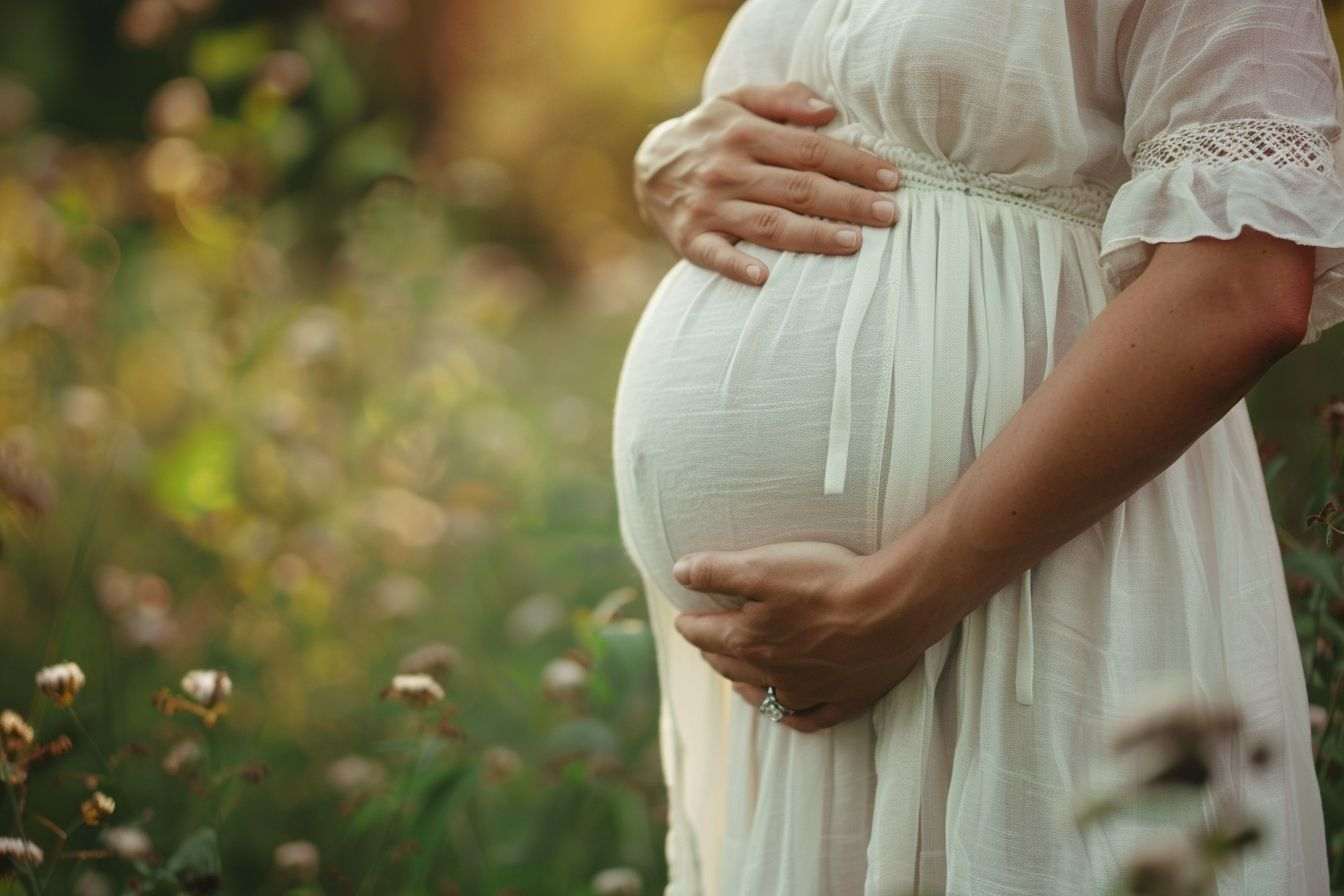 Femme enceinte caressant son ventre en plein air