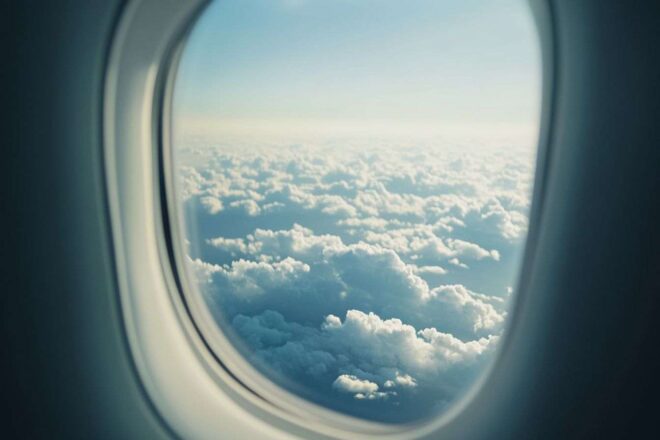 Image d'illustration. Gros plan d un hublot d avion avec des nuages et lumière du soleil