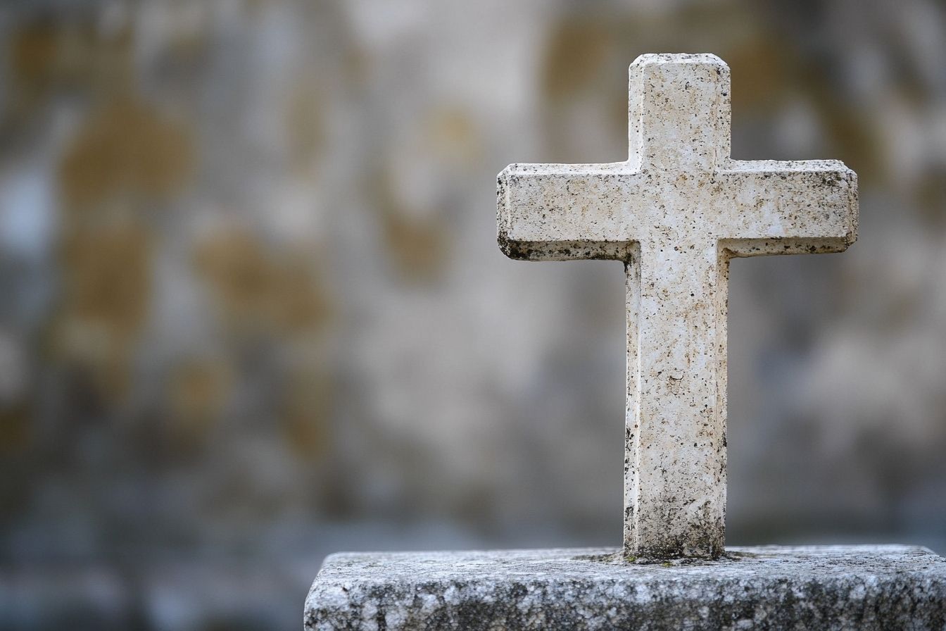 Image d'illustration. Gros plan d une croix chrétienne en béton devant une église sereine