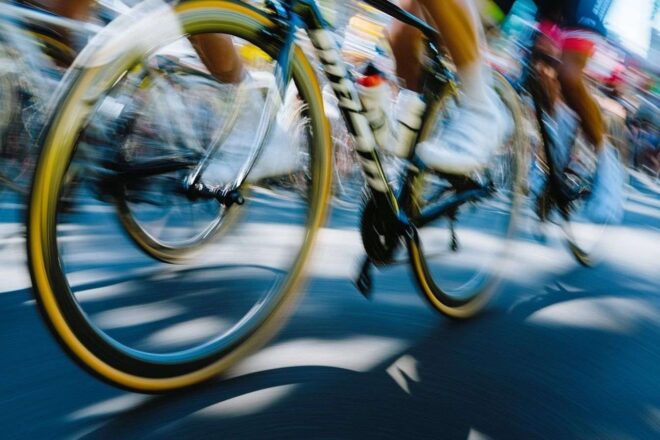 Gros plan des roues de vélo tournant rapidement pendant le Tour de France, capturant le mouvement et l'excitation.