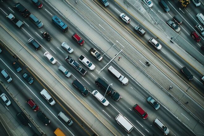 Vue aérienne d'une autoroute congestionnée montrant des flots de véhicules circulant dans les deux sens.
