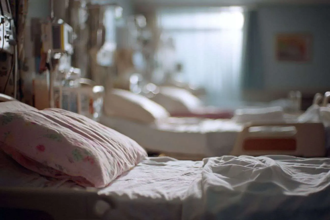 Image des lits d'hôpital dans une salle d'urgence avec équipements modernes et literie récente