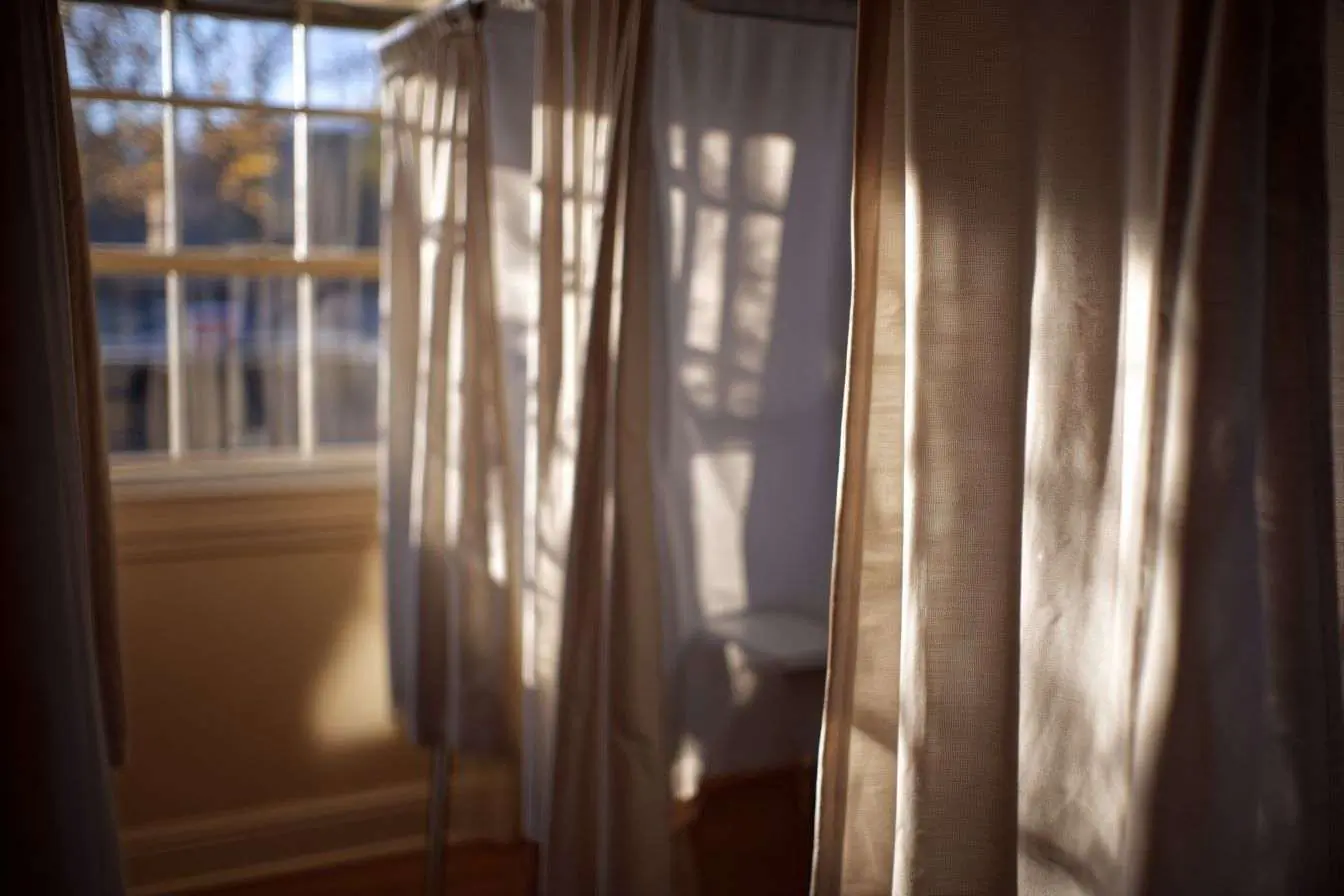 Cabine de vote sans occupant illuminée par le soleil, offrant intimité et calme.