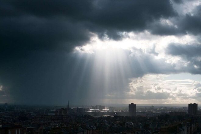 Soleil perçant à travers les nuages sombres sur la ville