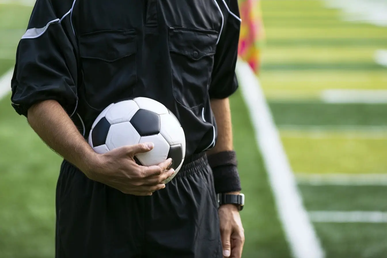 Arbitre de soccer avec ballon sous le bras