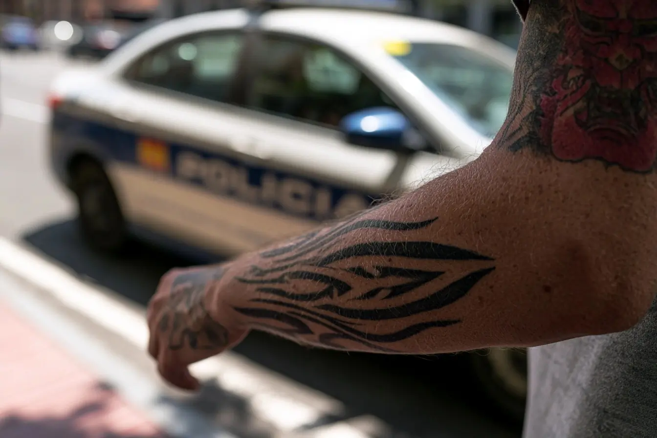 Tatouages au premier plan, police derrière
