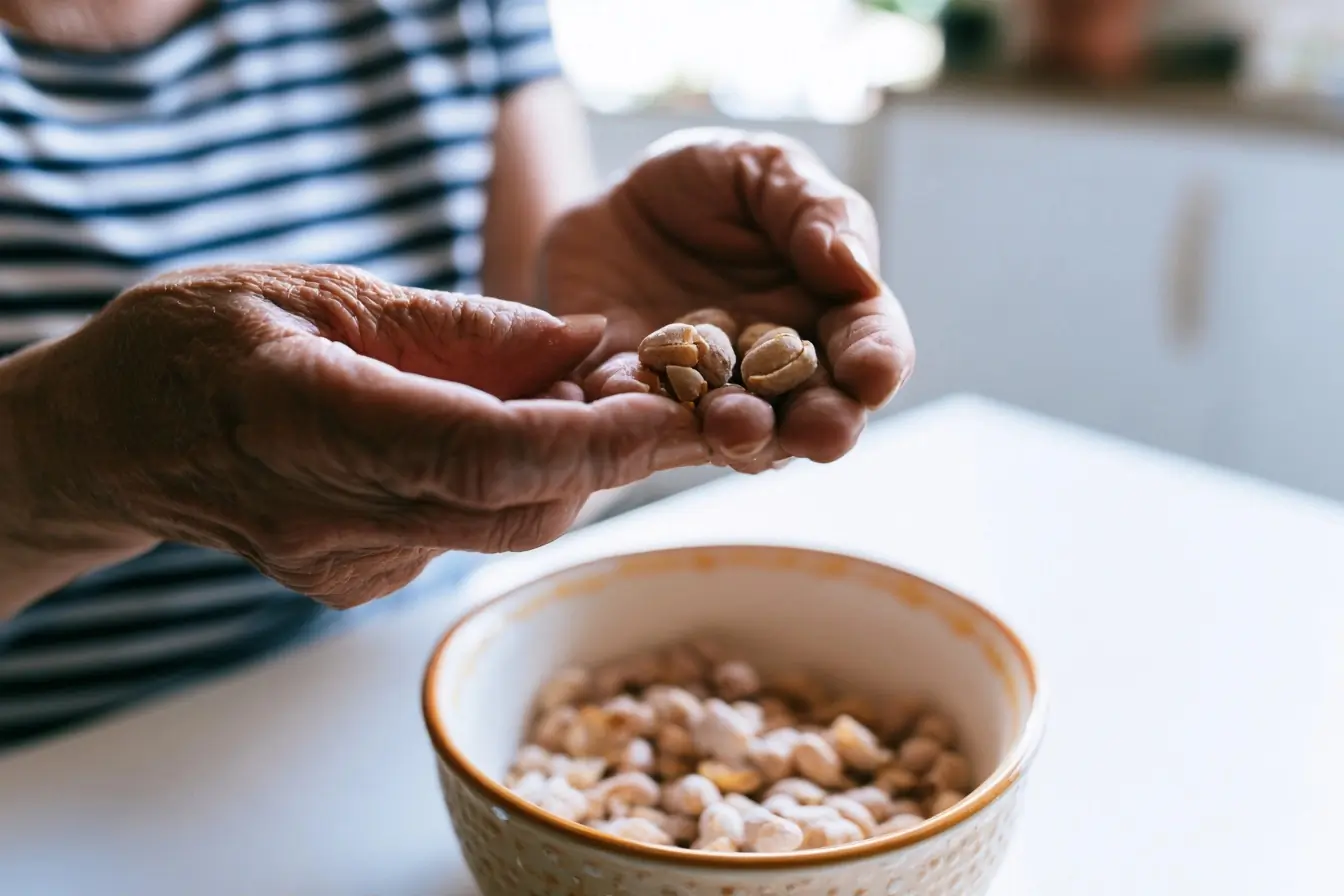 Main âgée tenant des cacahuètes en cuisine